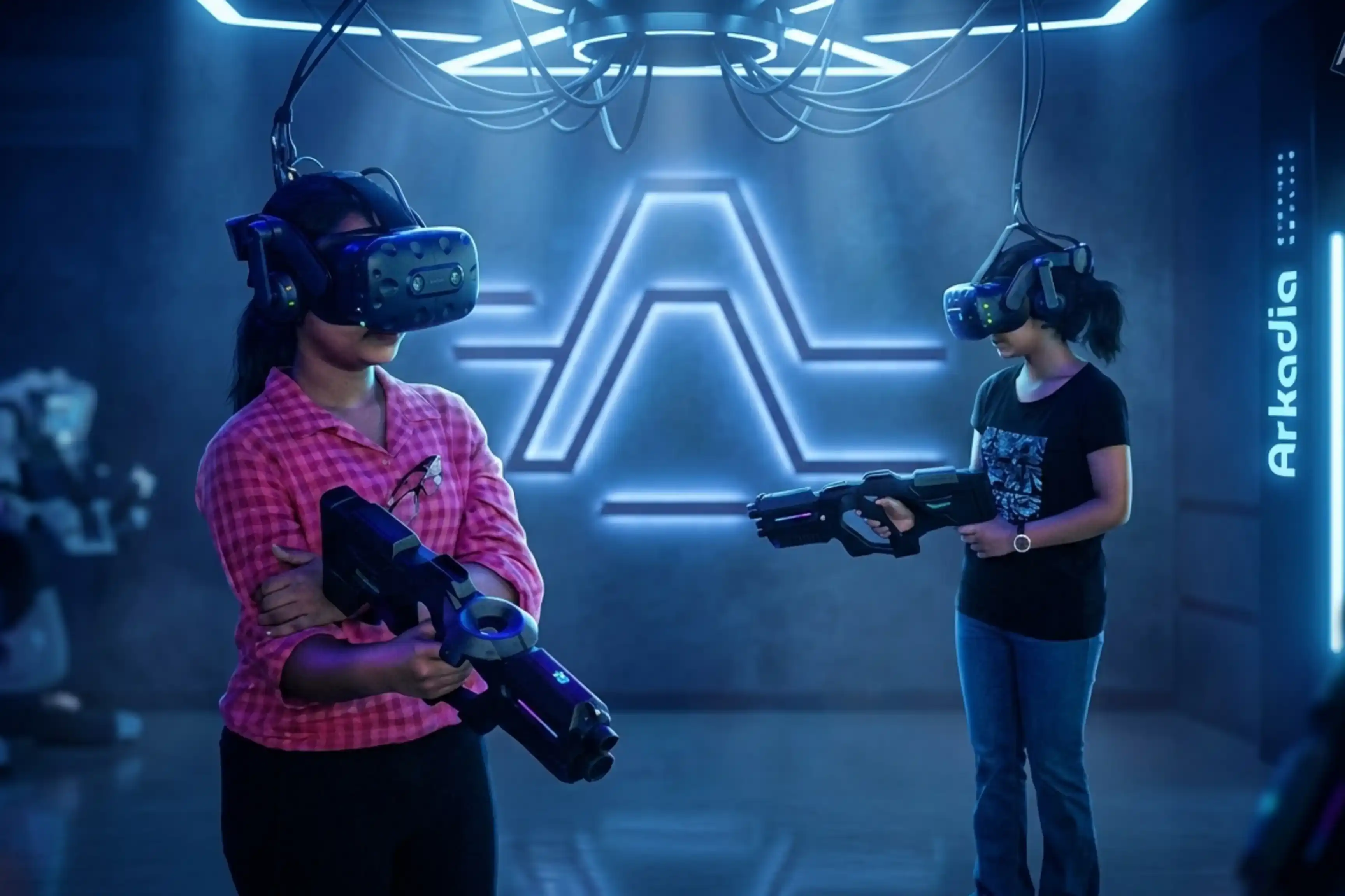 Two people wearing VR headsets and holding blaster guns in the Arkadia VR Arena