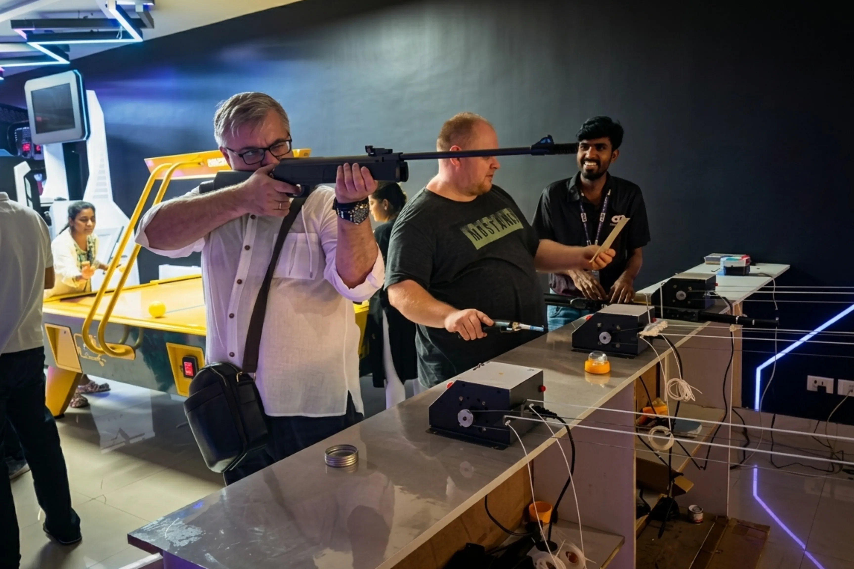 Player aiming air gun with Game Xtreme staff supervising the session